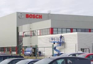 Anbringen der Lamellenverkleidung am Bosch Vordach durch Arbeiter auf blauer Hebebühne